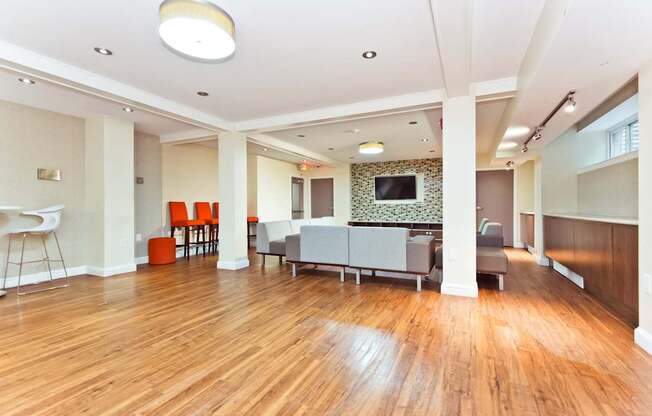 A living room with a television and a wooden floor.