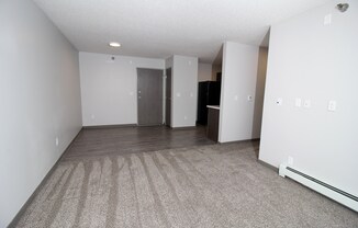 an empty living room with a carpeted floor and white walls