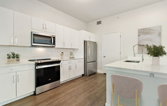 a modern kitchen with white cabinets and stainless steel appliances