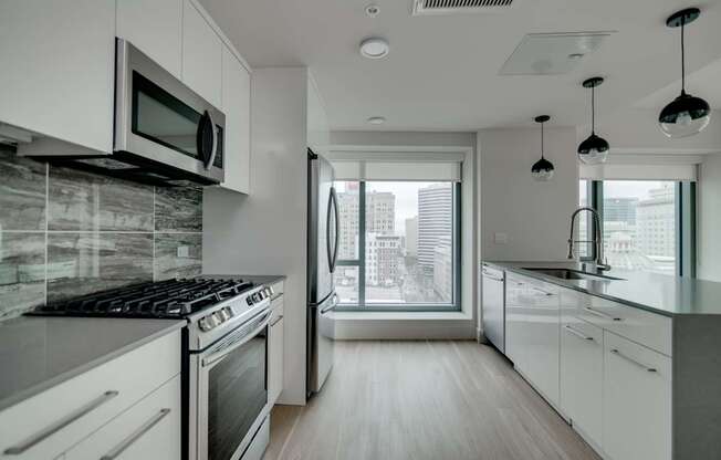 A modern kitchen with white cabinets and a black stove top.