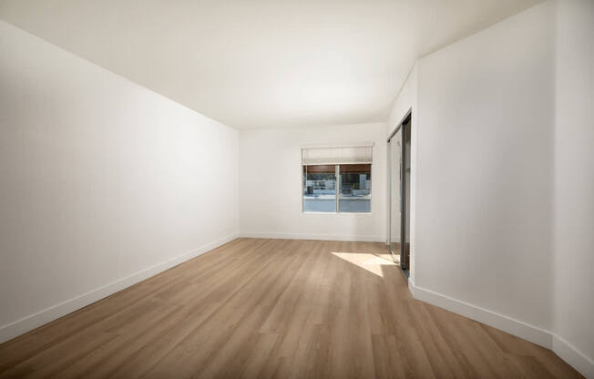 A room with wooden flooring and white walls.