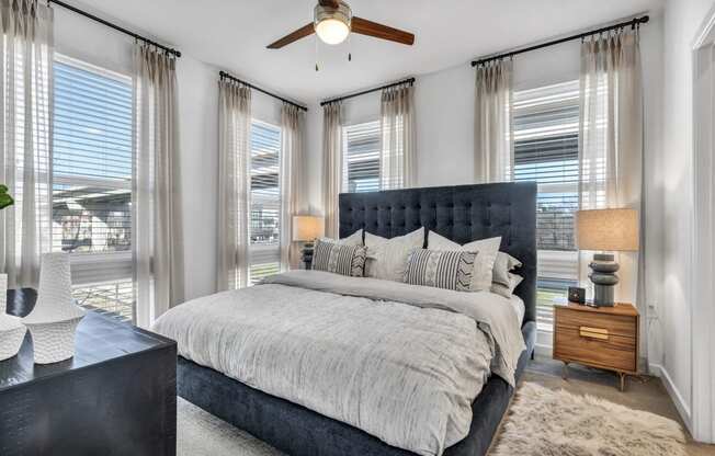 a bedroom with a large bed and a ceiling fan