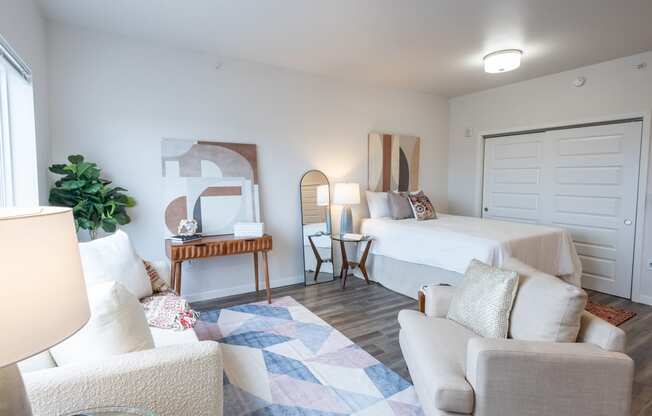 a bedroom with a bed and a living room with a couch and a chair at Technology Park Apartments, Minnesota, 55901