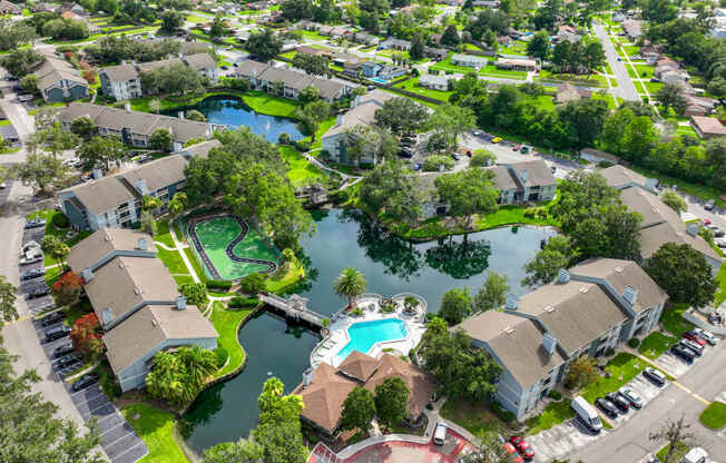 an aerial view of the resort style community with a swimming pool and tennis court