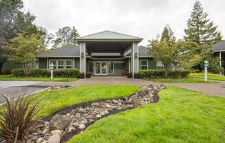 A green building with a stone pathway leading to the entrance.