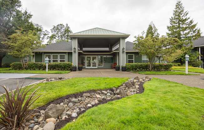 A green building with a stone pathway leading to the entrance.