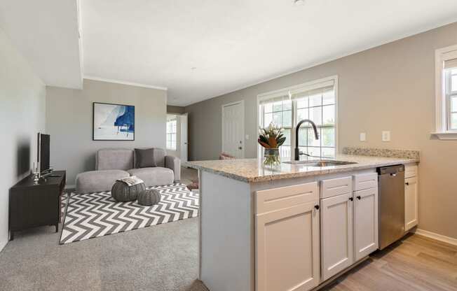 a kitchen with an island and a living room in the background