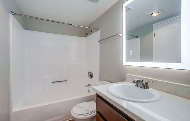 A white toilet sits next to a white sink in a bathroom.