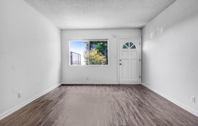 an empty room with a door and a window