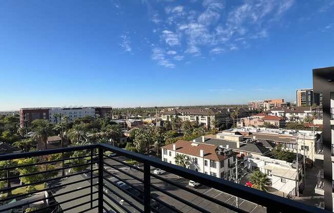 a balcony with a view of the city and palm trees