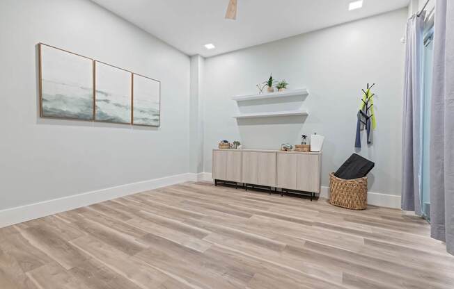 A room with a wooden floor and a painting on the wall.