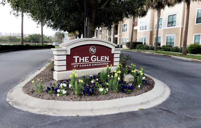 The sign for The Glen at Cagan Crossing is surrounded by flowers.