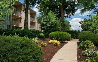 Walkway with lush green landscaping at Tysons Glen Apartments and Townhomes, Virginia
