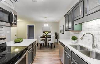 view of kitchen and dining area with stainless steel appliances and white counter tops and wood