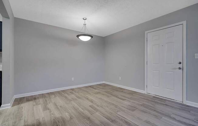 A room with a white door and a light hanging from the ceiling.