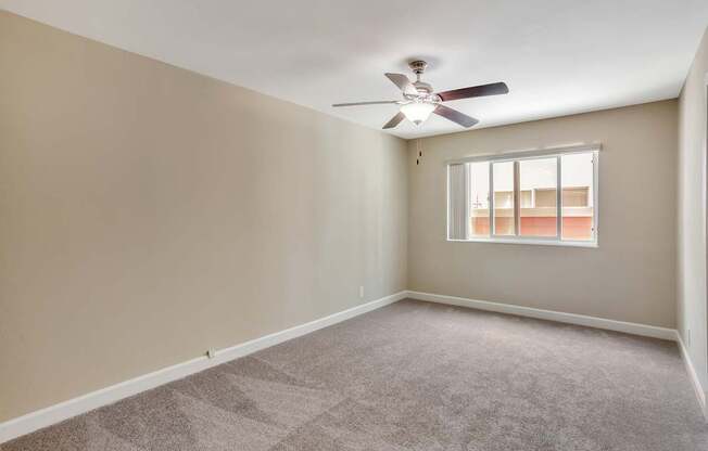A room with a ceiling fan and a window.