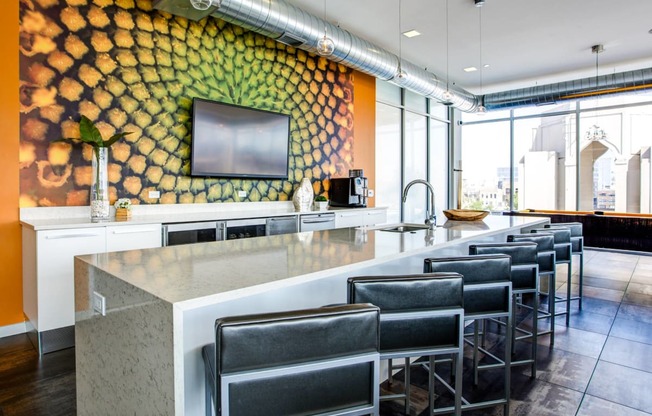 a bar with chairs in front of a counter and a yellow wall