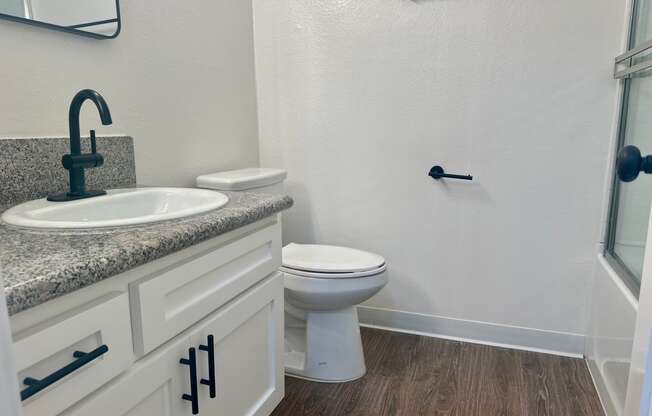 a bathroom with a toilet and a sink and a shower