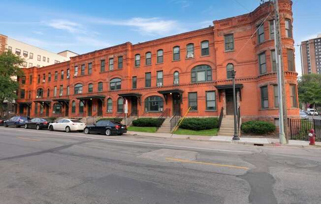 a red brick building on a street corner with cars parked in front of it