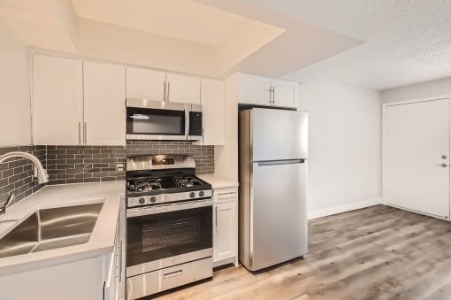 a kitchen with white cabinets and stainless steel appliances