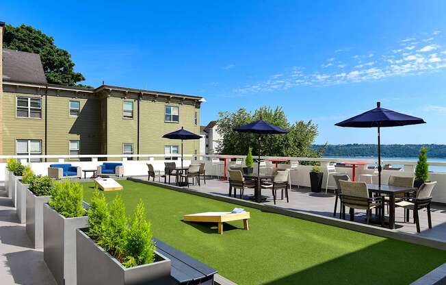 A patio with a table and chairs overlooking a body of water.