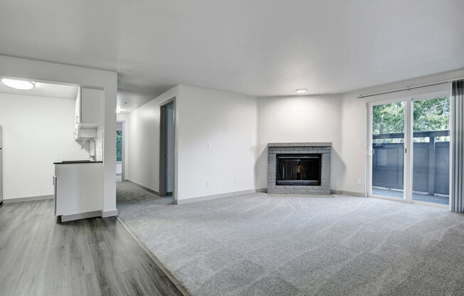 a living room with a fireplace and a kitchen