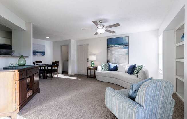 Lounge area in the model unit at Skyler Ridge Apartments, with a couch and ceiling fan.