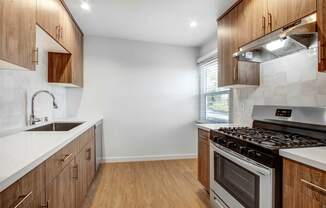 a kitchen with wooden cabinets and white counter tops and a stainless steel stove