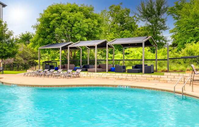 swimming pool with lounge chairs at the resort on a sunny day