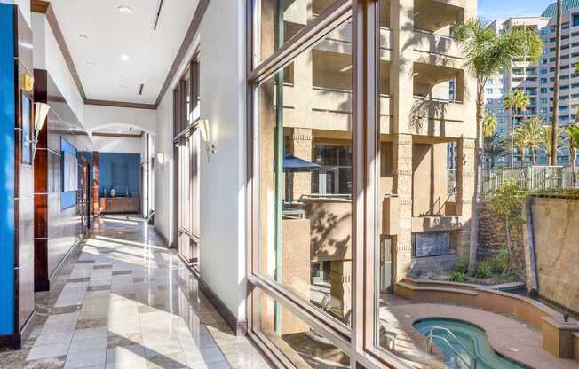 A long hallway with a pool outside the window.