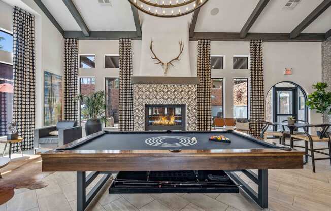 a pool table in the lobby of a building with a fireplace