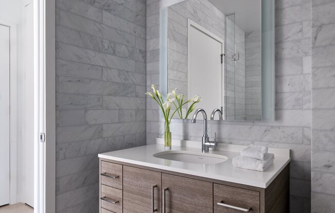A bathroom with a sink and a mirror.