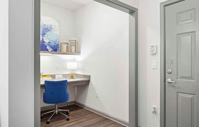 A room with a desk and a blue chair.