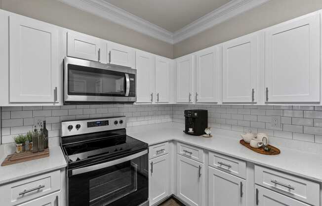 a kitchen with white cabinets and black appliances and a microwave