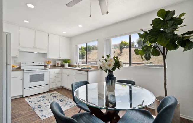 an open kitchen and dining area with a glass table and chairs