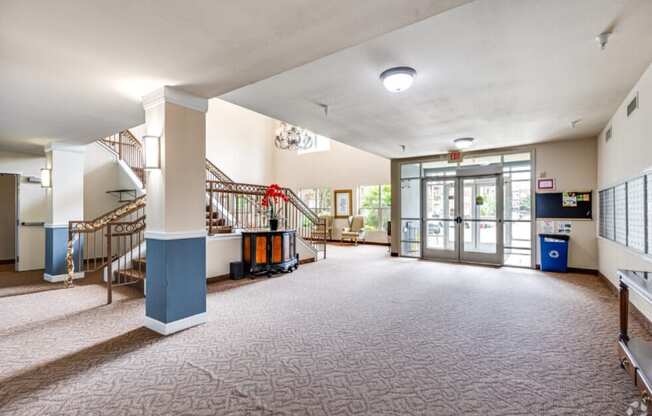 the lobby of a community center with stairs and a lobby door