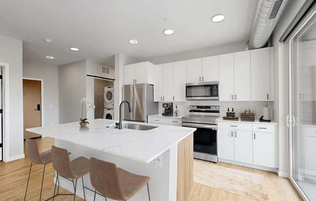 A modern kitchen with white cabinets and a large island.