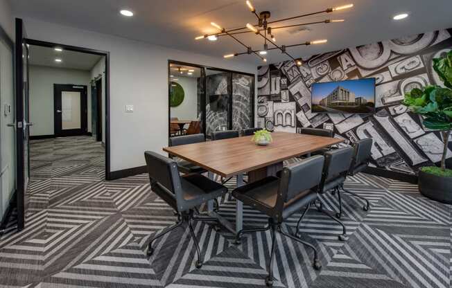 a meeting room with a large table and chairs and a mural on the wall