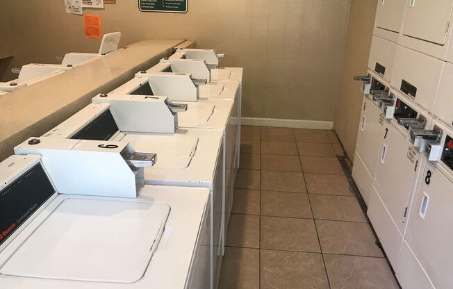 A row of white copiers are lined up in a room.