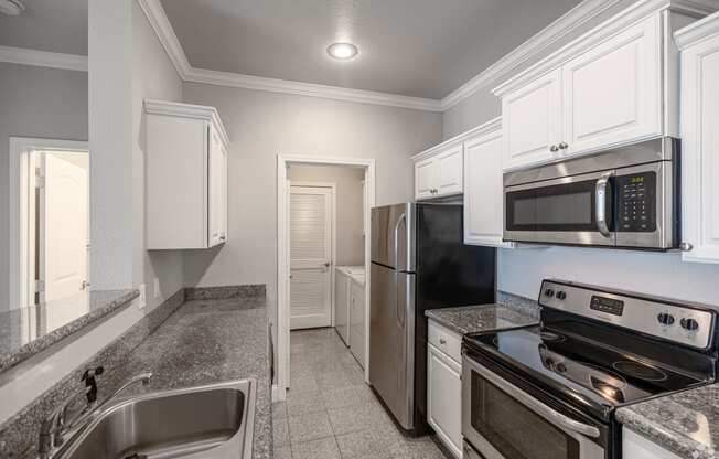 a kitchen with stainless steel appliances and white cabinets