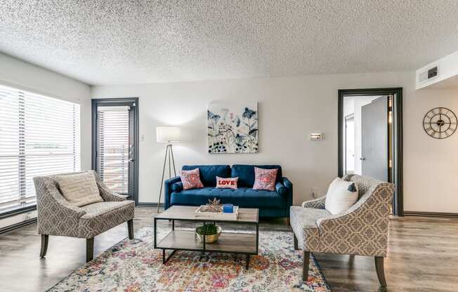 a living room with a blue couch and two chairs