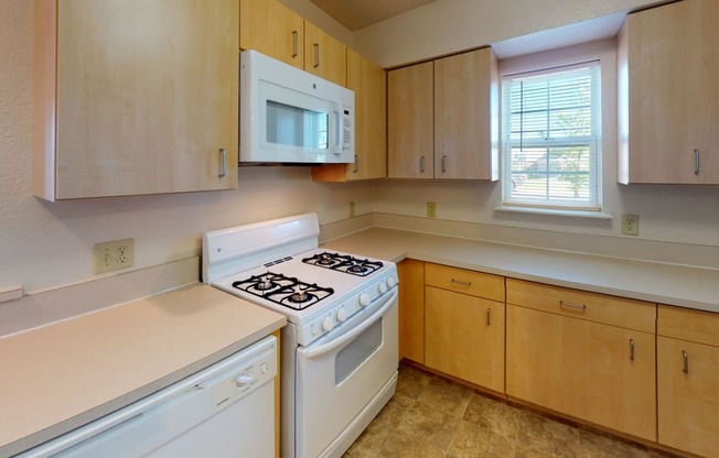 End style kitchen with white appliances and wooden cabinets