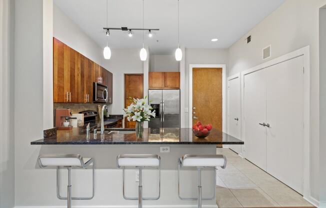 a kitchen with an island with three stools in front of it