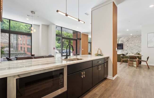 A modern kitchen with dark wood cabinets and a marble countertop.