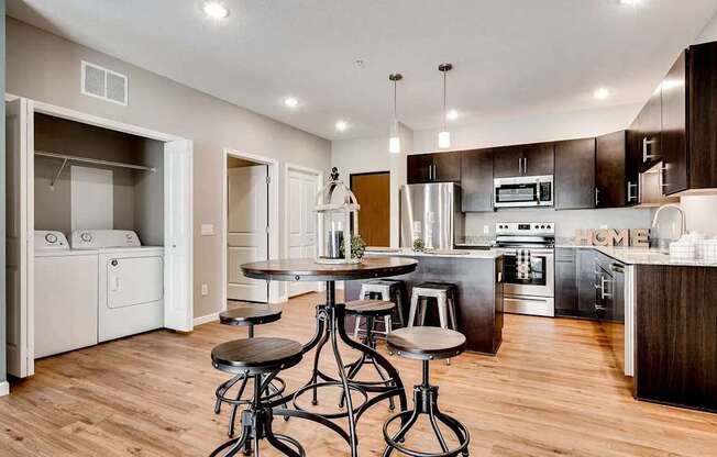an open kitchen and dining room with a bar and stools. Circle Pines, MN Lexington Lofts