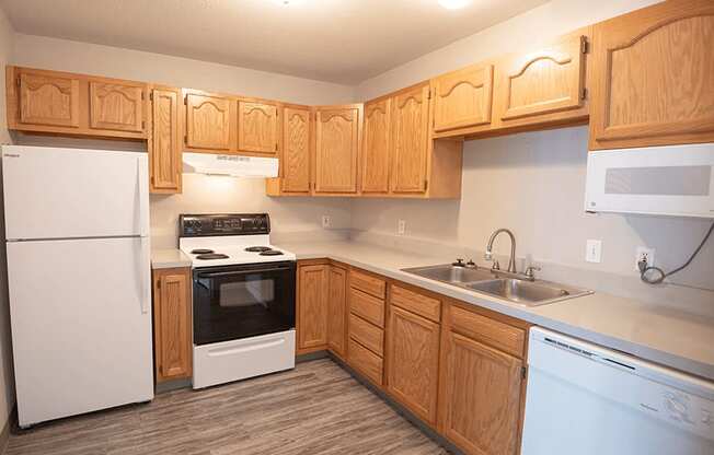 a kitchen with white appliances and wooden cabinets