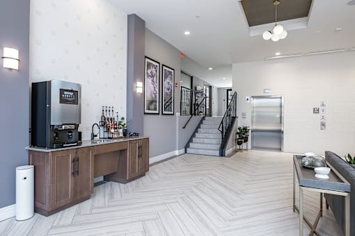 a resident lobby with a coffee bar and stairs to the second floor