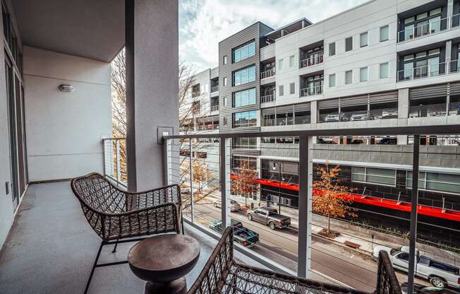 a balcony with a chair and a table overlooking a city street at 20 Midtown, Birmingham, 35233