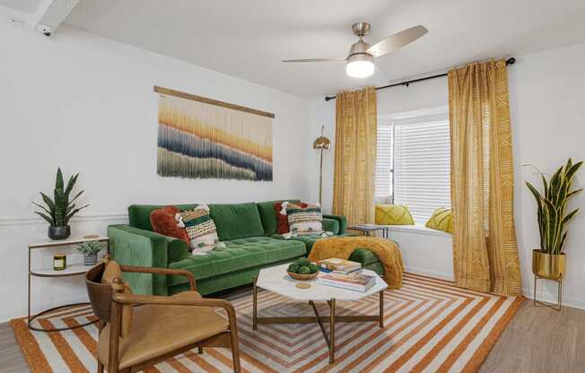 a living room with a green couch and yellow curtains