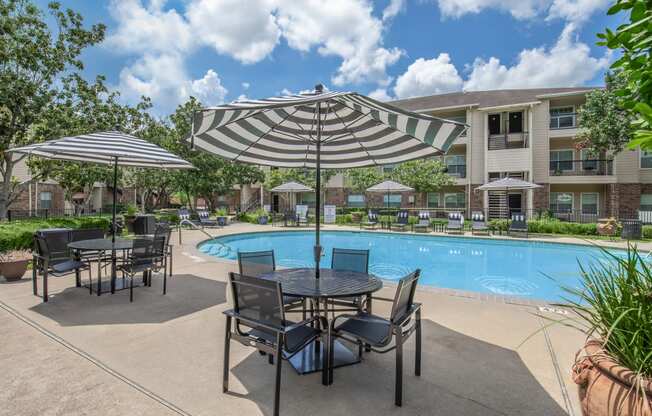 Pet-Friendly Apartments in Houston, TX – Westchase Forest – Photo of our apartments offer a swimming pool with tables and umbrellas